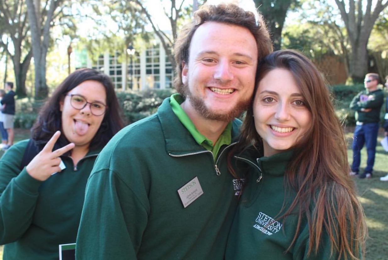 Three students working at an event.